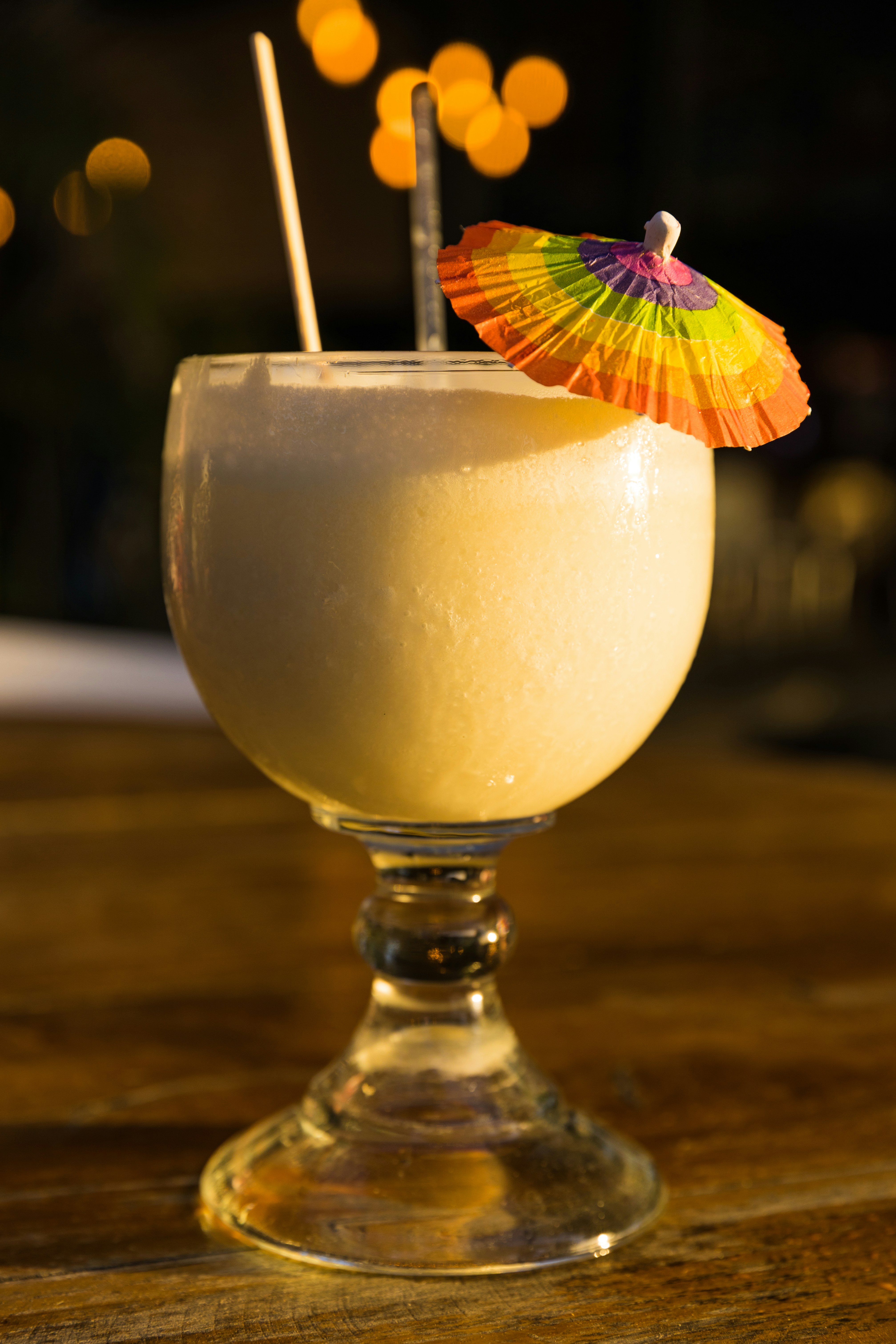 Frozen coconut-cream cocktail in a vintage goblet with umbrella.