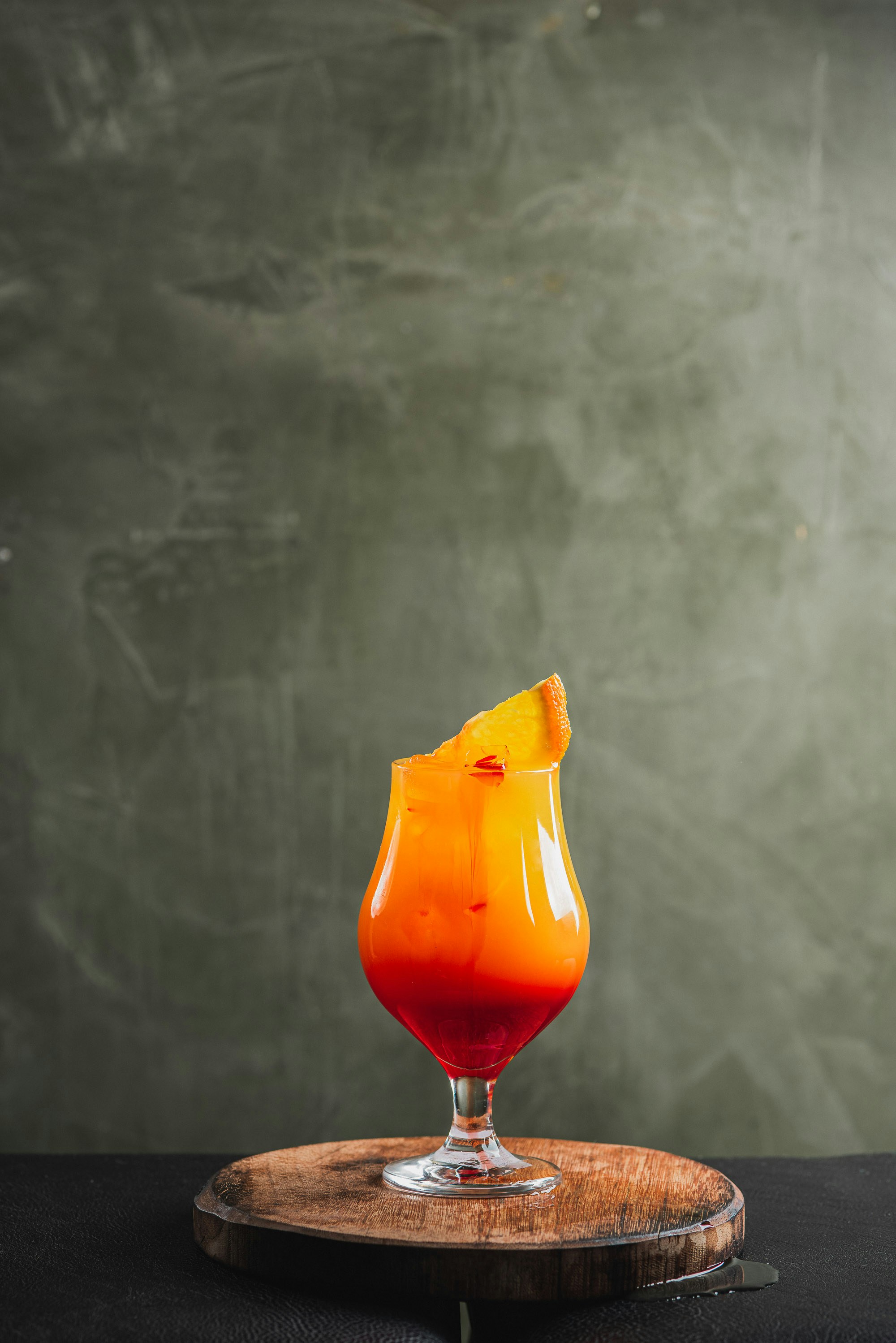 Tulip glass with layered orange-to-red tequila sunrise.